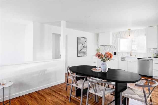 dining space with hardwood / wood-style floors and sink