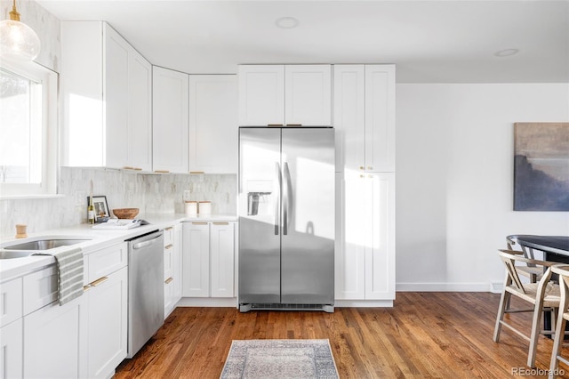 kitchen with hardwood / wood-style floors, white cabinets, and stainless steel appliances