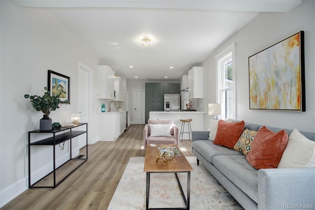 living room with light hardwood / wood-style flooring and sink