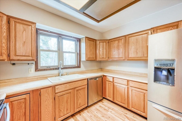 kitchen featuring stainless steel dishwasher, a sink, white refrigerator with ice dispenser, and light countertops
