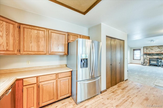 kitchen featuring light countertops, open floor plan, appliances with stainless steel finishes, and light wood-style flooring