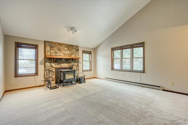unfurnished living room featuring carpet, a wealth of natural light, baseboard heating, and a wood stove