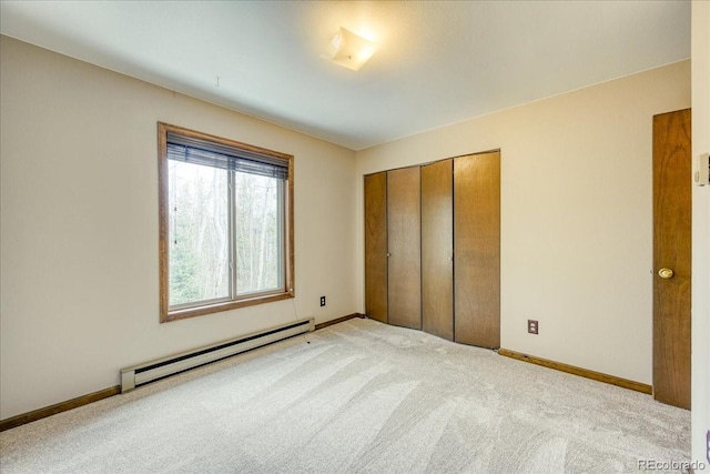 unfurnished bedroom featuring a closet, baseboards, baseboard heating, and carpet flooring