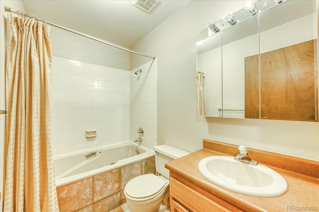 full bath with visible vents, tiled shower / bath, toilet, and vanity