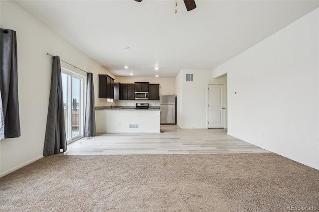 kitchen featuring light carpet, ceiling fan, and appliances with stainless steel finishes