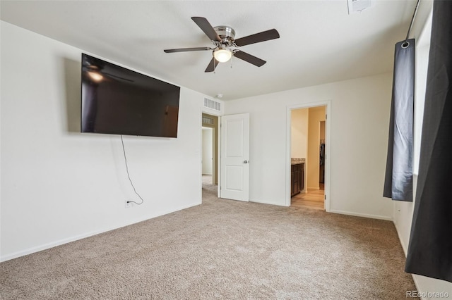 unfurnished bedroom featuring light carpet, connected bathroom, and ceiling fan