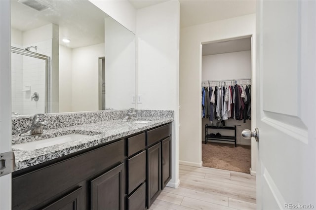 bathroom with vanity, wood-type flooring, and an enclosed shower