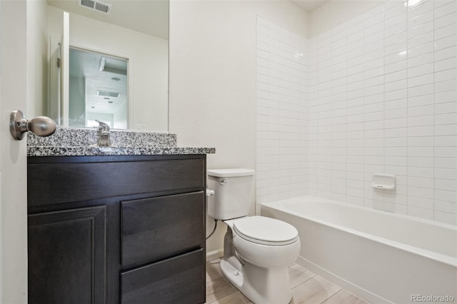 full bathroom featuring tiled shower / bath, vanity, and toilet