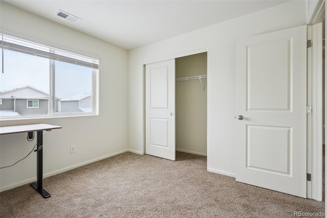 unfurnished bedroom featuring a closet and light carpet