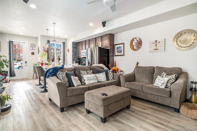 living room featuring light wood-type flooring and ceiling fan