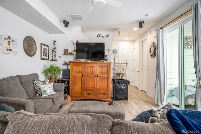 living room featuring ceiling fan and light hardwood / wood-style floors