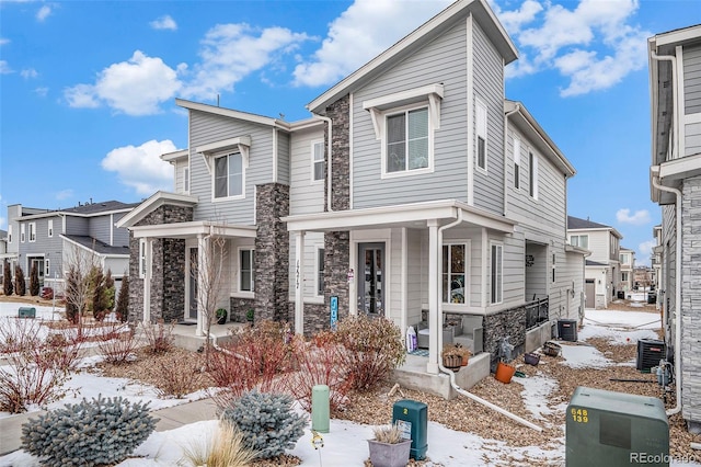 multi unit property with stone siding, covered porch, and central AC