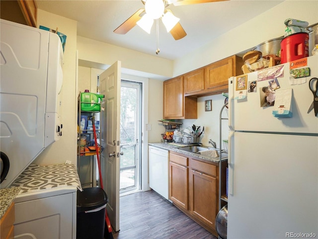 kitchen featuring dark wood-style flooring, brown cabinets, light countertops, a sink, and white appliances