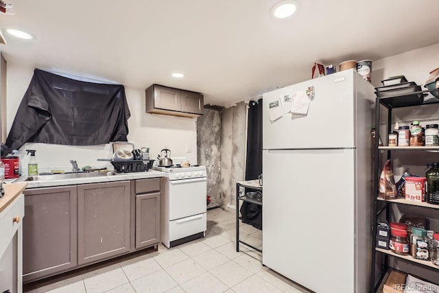 kitchen with white appliances, light countertops, gray cabinetry, a sink, and recessed lighting