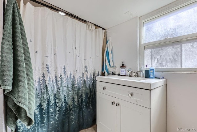 bathroom with curtained shower and vanity