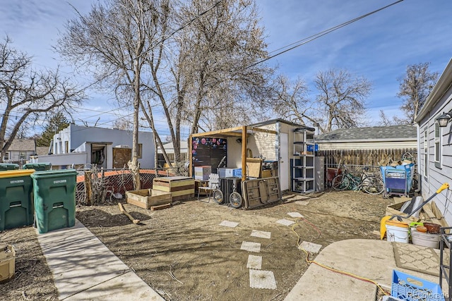 view of yard featuring an outbuilding, fence, and a shed