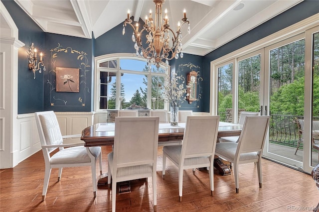 dining area featuring beamed ceiling, wood-type flooring, ornamental molding, and a notable chandelier