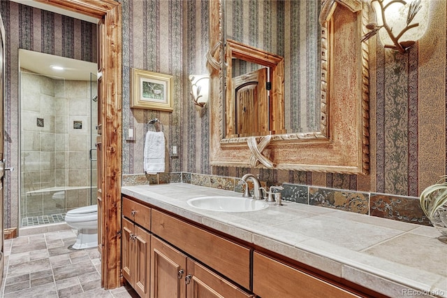 bathroom with an enclosed shower, vanity, and toilet