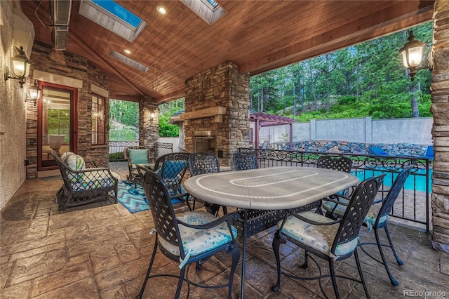 view of patio featuring an outdoor stone fireplace and a pool