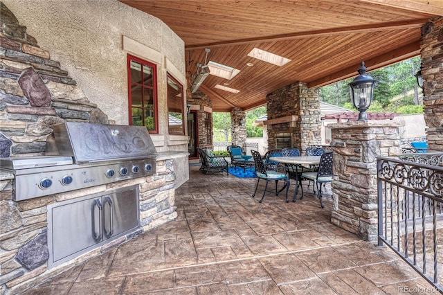 view of patio / terrace featuring a grill, area for grilling, and an outdoor stone fireplace