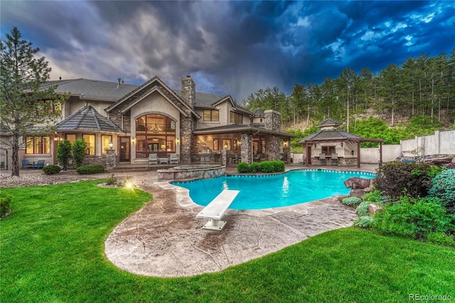 pool at dusk with a gazebo, a patio, a diving board, and a lawn