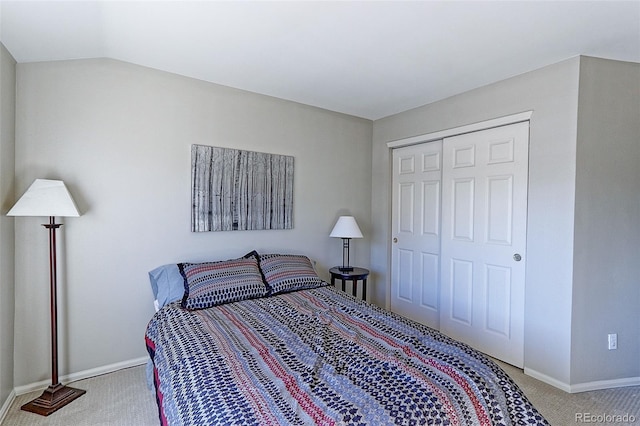 bedroom with carpet floors, vaulted ceiling, and a closet