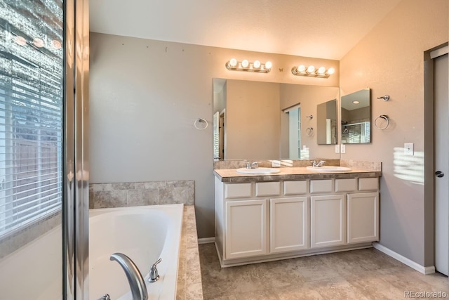 bathroom featuring vanity and tiled tub