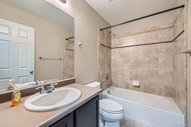 full bathroom featuring vanity, tiled shower / bath combo, and toilet