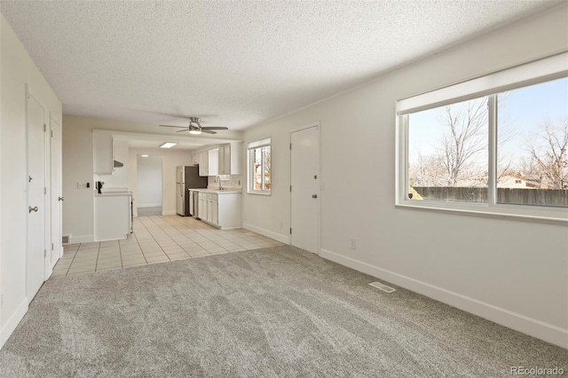 9562 W Capri Dr, Littleton, CO 80123 - unfurnished living room featuring visible vents, a sink, ceiling fan, a textured ceiling, and light carpet