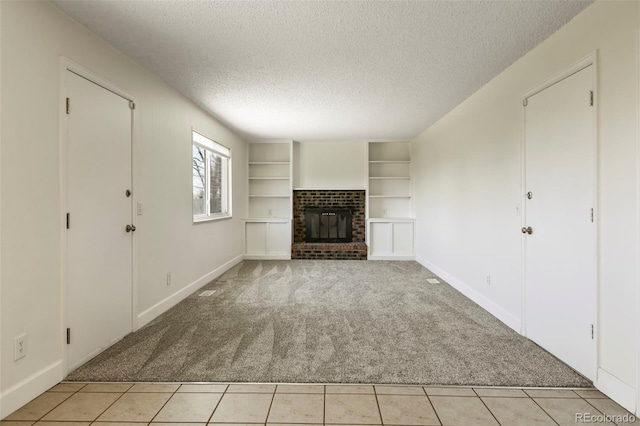 9562 W Capri Dr, Littleton, CO 80123 - unfurnished living room featuring built in features, a fireplace, a textured ceiling, light tile patterned flooring, and light colored carpet