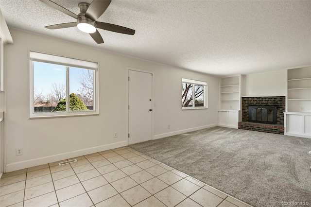 9562 W Capri Dr, Littleton, CO 80123 - unfurnished living room featuring light carpet, built in shelves, visible vents, and a textured ceiling