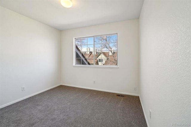 empty room with carpet floors, baseboards, and visible vents