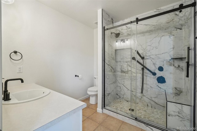 bathroom featuring toilet, tile patterned flooring, a marble finish shower, and vanity