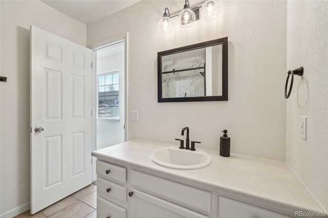 full bath with a stall shower, vanity, and tile patterned floors