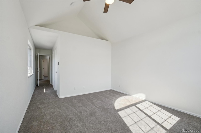 carpeted spare room with vaulted ceiling, a ceiling fan, and baseboards