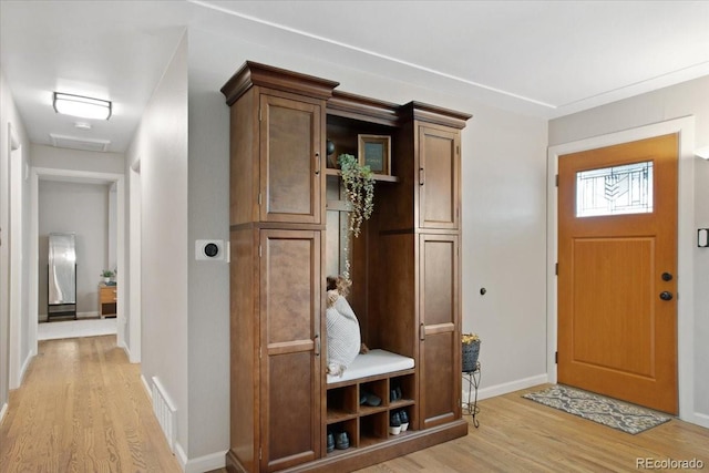 mudroom with baseboards, light wood finished floors, and visible vents
