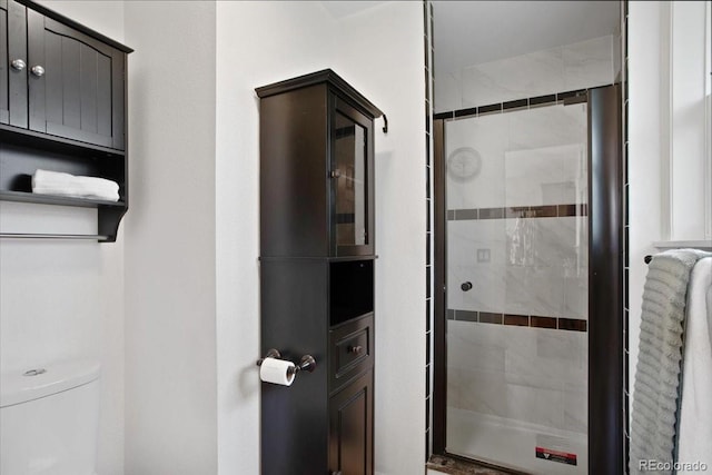 full bath featuring a stall shower and toilet