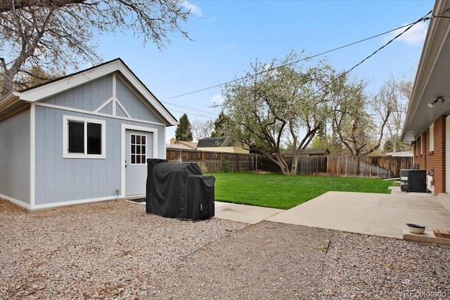 view of yard with cooling unit, an outbuilding, a fenced backyard, and a patio area