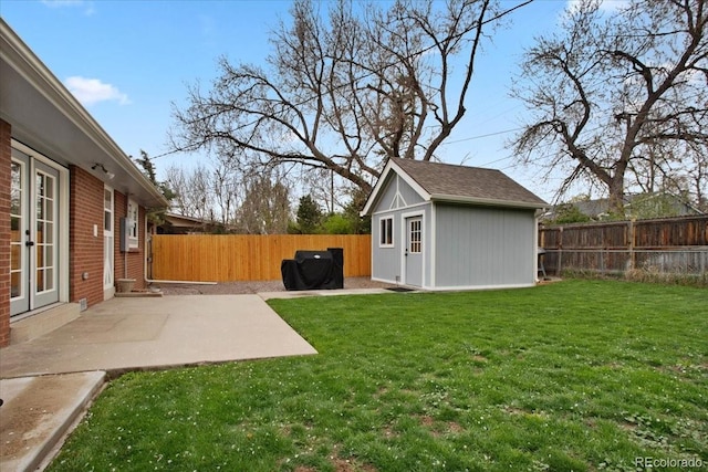 view of yard featuring french doors, a patio, an outbuilding, and a fenced backyard