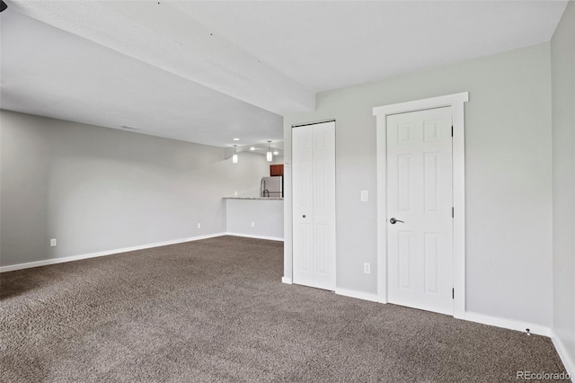 128 W Rockrimmon Blvd Unit 105, Colorado Springs, CO 80919 - unfurnished living room featuring dark carpet and baseboards