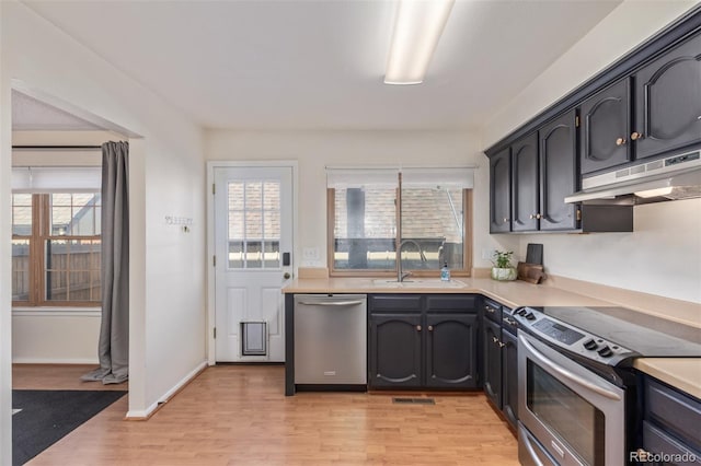 8039 E Phillips Cir, Centennial, CO 80112 - kitchen with stainless steel appliances, light wood finished floors, light countertops, and under cabinet range hood