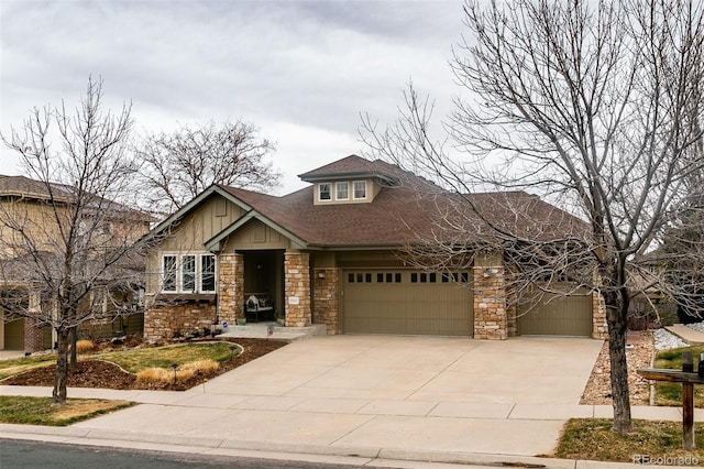 craftsman-style house featuring board and batten siding, stone siding, an attached garage, and concrete driveway