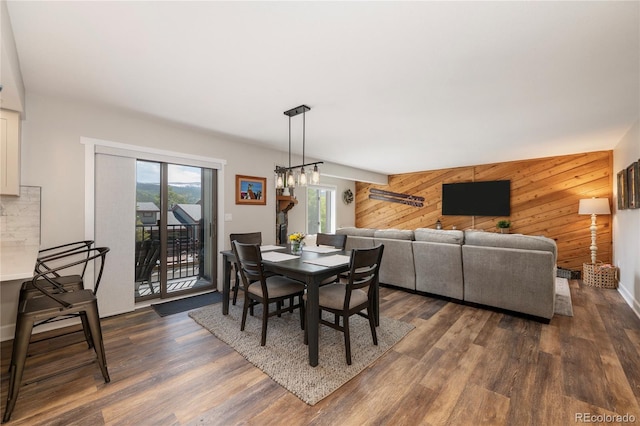 141 Forest Trl # 16, Winter Park, CO 80482 - dining area featuring wooden walls, healthy amount of natural light, dark wood-style floors, and an accent wall