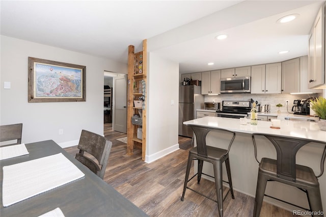 141 Forest Trl # 16, Winter Park, CO 80482 - kitchen featuring appliances with stainless steel finishes, dark wood finished floors, a kitchen breakfast bar, light countertops, and recessed lighting