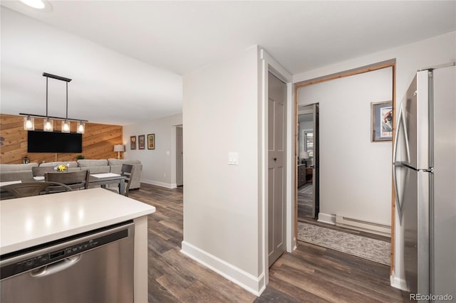 141 Forest Trl # 16, Winter Park, CO 80482 - kitchen with appliances with stainless steel finishes, wooden walls, dark wood-style floors, light countertops, and a baseboard radiator