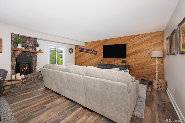 141 Forest Trl # 16, Winter Park, CO 80482 - living room with wood walls, a stone fireplace, wood finished floors, and an accent wall