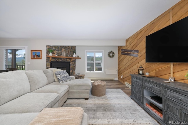 141 Forest Trl # 16, Winter Park, CO 80482 - living room with wood finished floors, wood walls, baseboard heating, and a fireplace