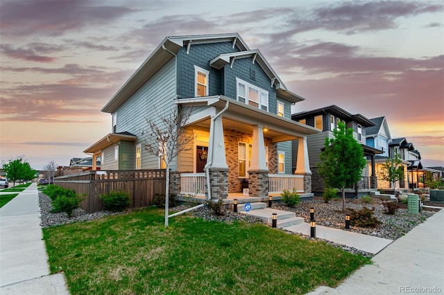 21492 E 60th Ave, Aurora, CO 80019 - craftsman house featuring a front yard, a porch, and fence