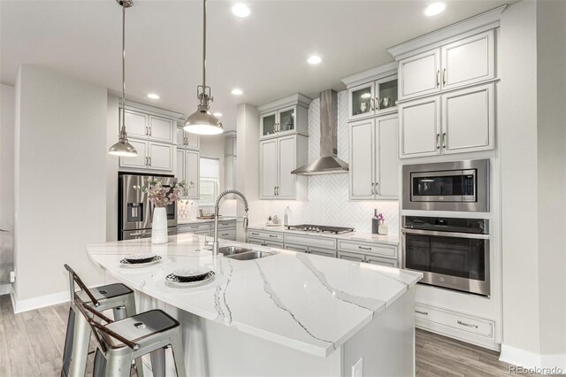 21492 E 60th Ave, Aurora, CO 80019 - kitchen with a sink, wall chimney exhaust hood, stainless steel appliances, light stone countertops, and decorative backsplash