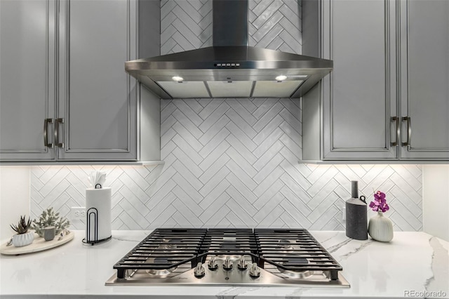 21492 E 60th Ave, Aurora, CO 80019 - kitchen featuring stainless steel gas cooktop, wall chimney exhaust hood, backsplash, light stone countertops, and gray cabinetry